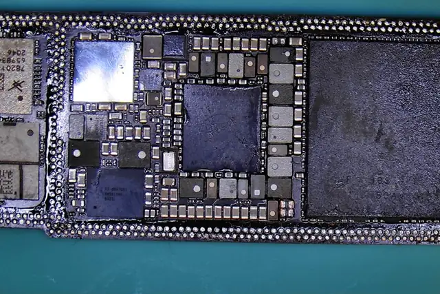 Carte mère d’iPhone ouverte sous le microscope : billes de soudure et composants